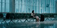 a woman sitting on a bench in an airport