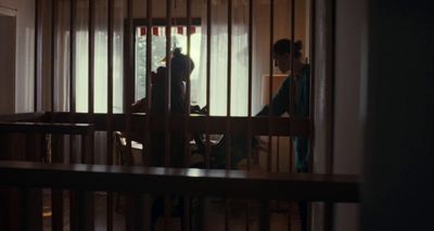 a person standing in a room behind bars
