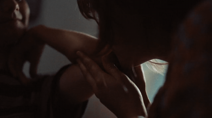 a woman standing in front of a mirror brushing her teeth