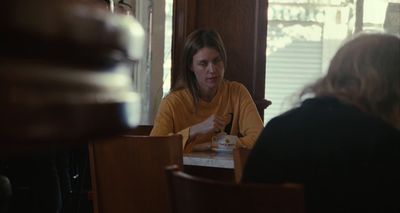a woman sitting at a table in a restaurant