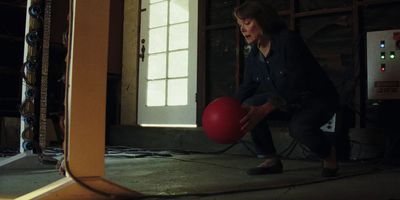 a woman holding a red ball in a room