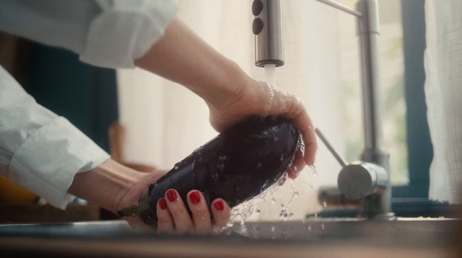 a woman washing her hands under a faucet