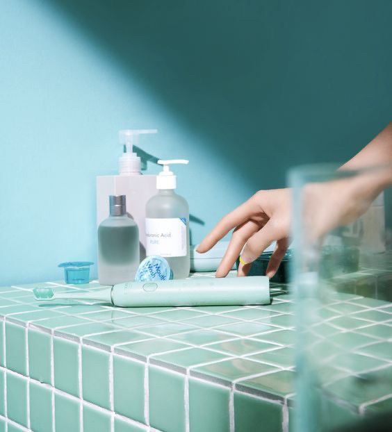 a person's hand reaching for a bottle of hand sanitizer on a