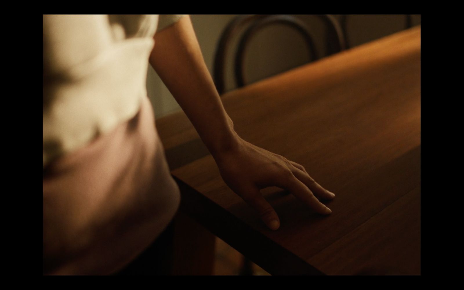 a person standing at a table with their hand on the table