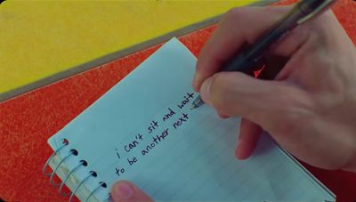 a person writing on a notepad with a pen