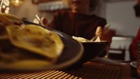 a woman sitting at a table with a plate of food