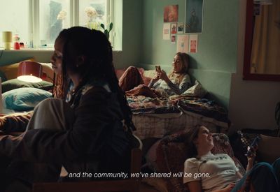 a group of people sitting on a bed in a room