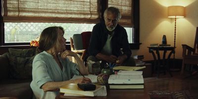 a man and a woman sitting at a table in a living room