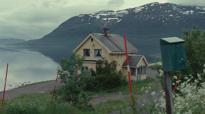 a house sitting on the side of a road next to a body of water