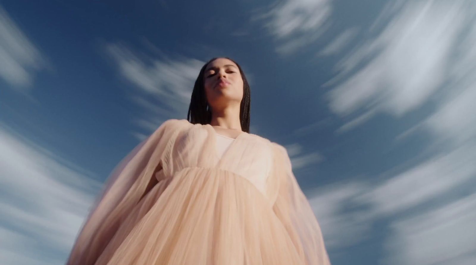 a woman in a dress looking up into the sky