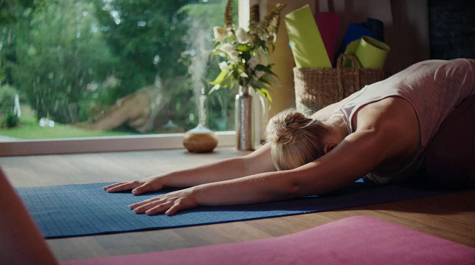 a woman laying on a yoga mat in front of a window