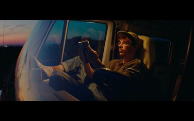 a man sitting in a car reading a book