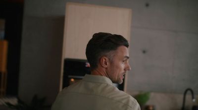 a man standing in a kitchen next to a stove top oven