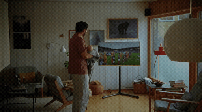 a man standing in a living room next to a window
