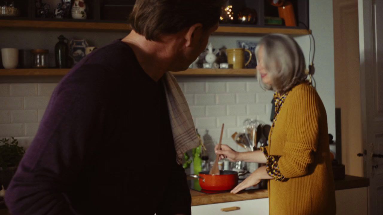 a man standing next to a woman in a kitchen