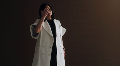 a woman in a white coat is covering her eyes