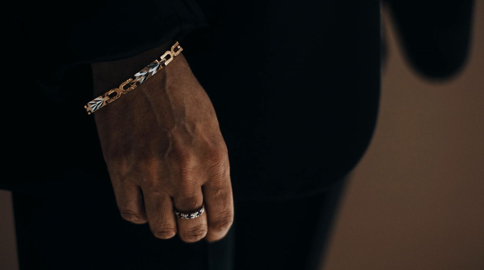 a man wearing a chain bracelet and a black shirt