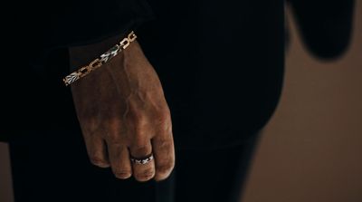 a man wearing a chain bracelet and a black shirt