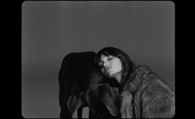 a black and white photo of a woman and a cow