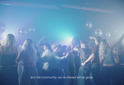 a group of people standing around each other in a room