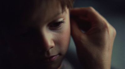 a close up of a child holding his head