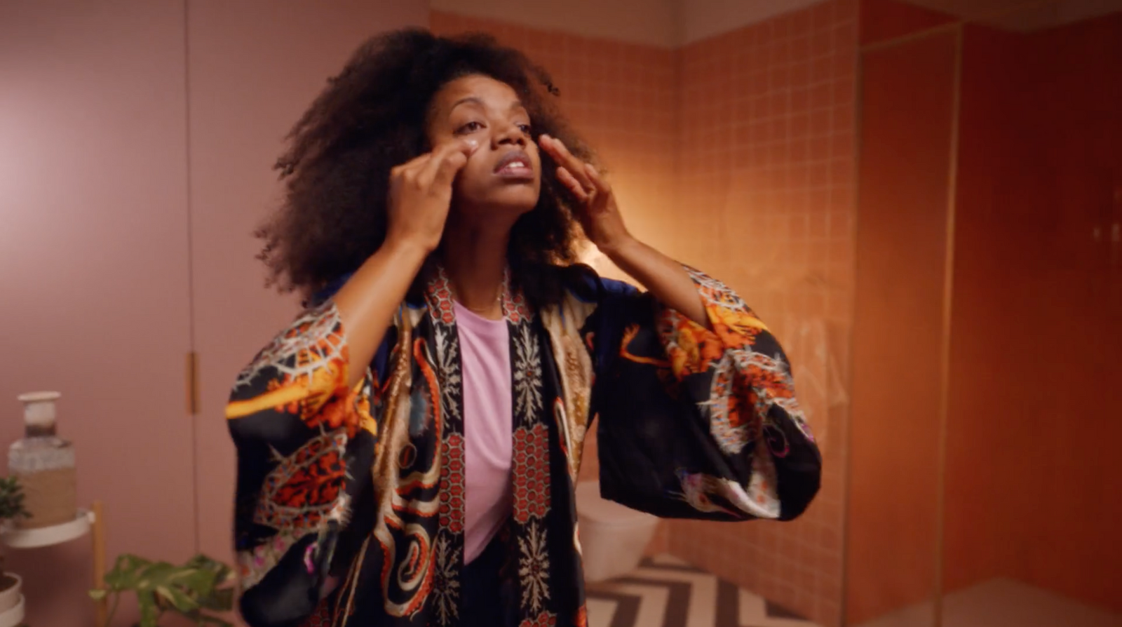 a woman in a bathroom brushing her hair