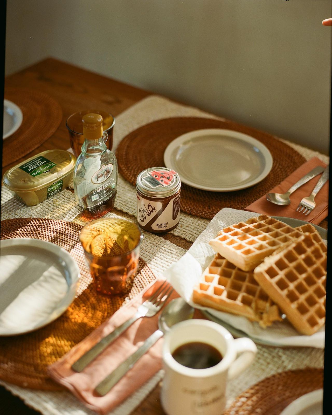 a table topped with waffles and syrup