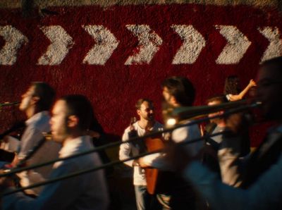 a group of people playing musical instruments in front of a wall