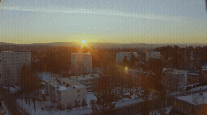 the sun is setting over a city in winter