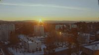 the sun is setting over a city in winter