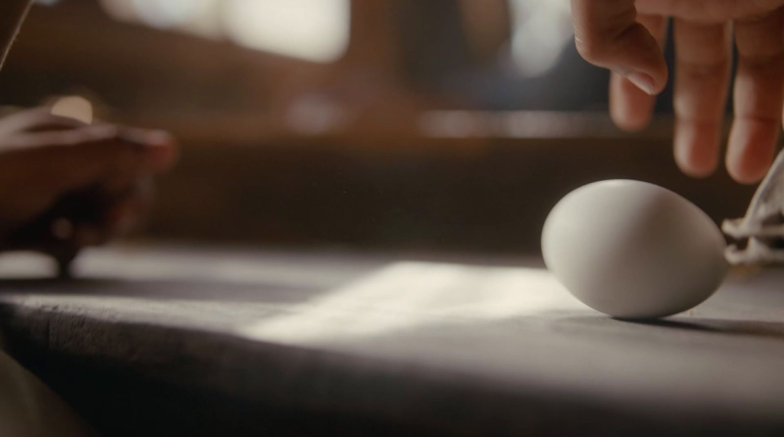 a close up of a person cutting an egg on a cutting board