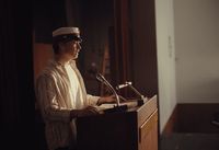 a man standing at a podium in front of a microphone