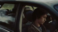a man sitting in a car using a cell phone