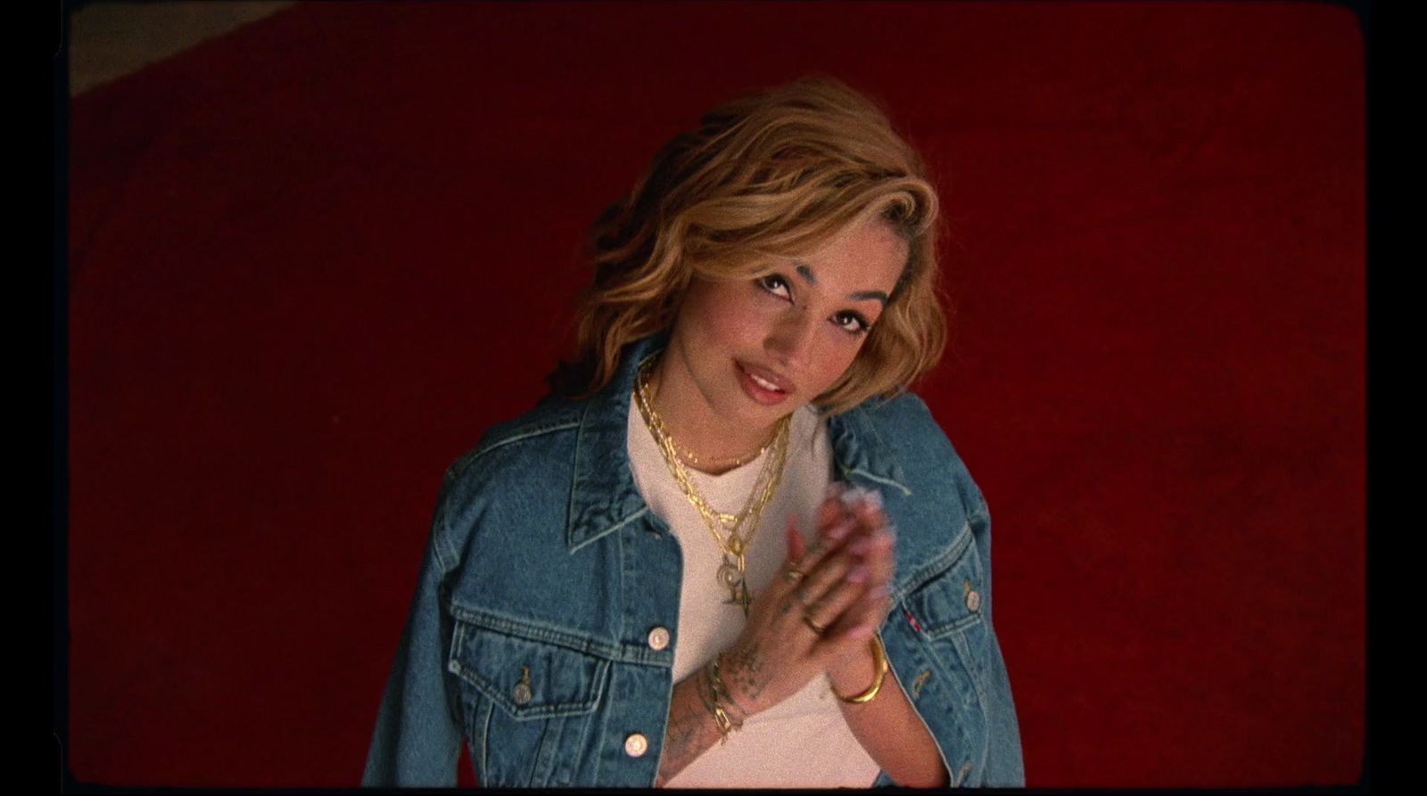 a woman in a jean jacket is posing for a picture