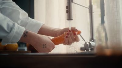 a woman is washing her hands with soap