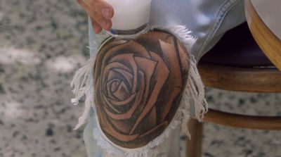 a person with a rose tattoo on their arm