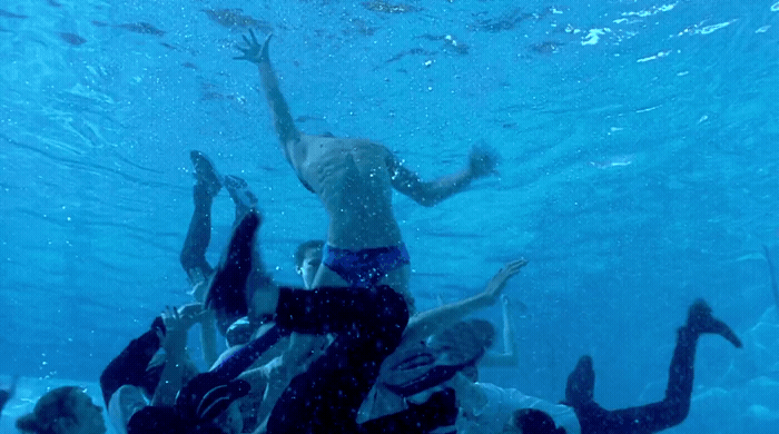 a group of people swimming under water in a pool