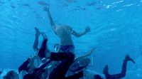 a group of people swimming under water in a pool