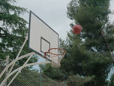 a basketball is in the air near a net