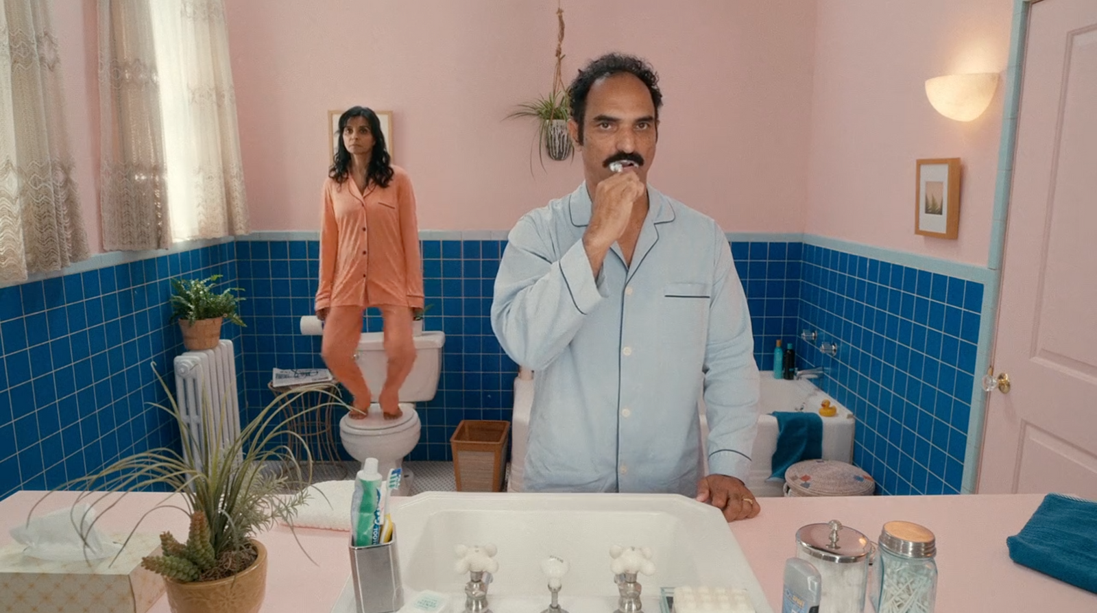 a man standing in front of a bathroom sink