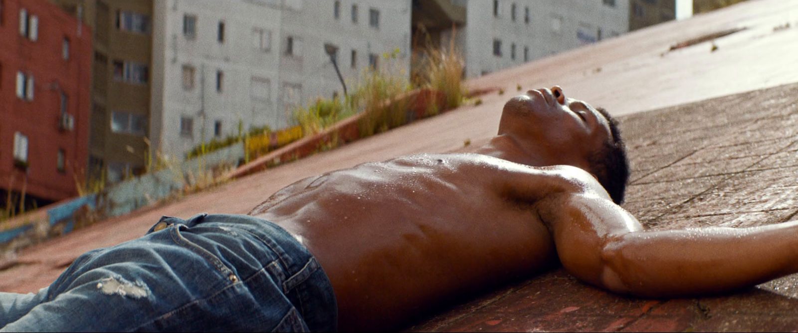 a man laying on the ground next to a building