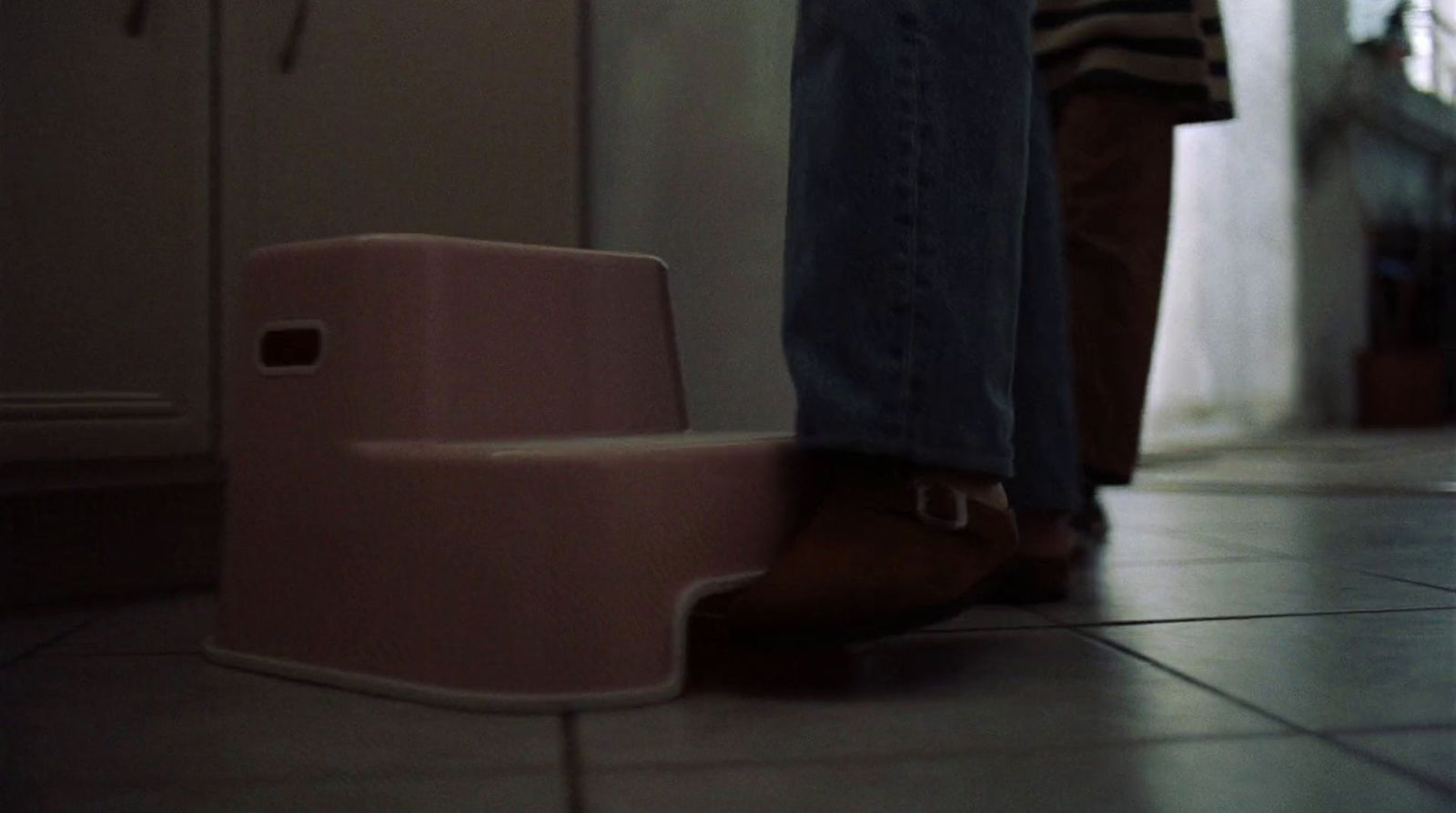 a person standing next to a pink step stool