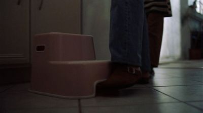 a person standing next to a pink step stool