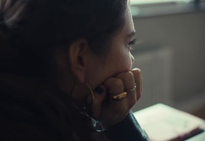 a woman sitting at a table with her hand on her face