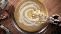 a person whisking batter into a bowl of batter