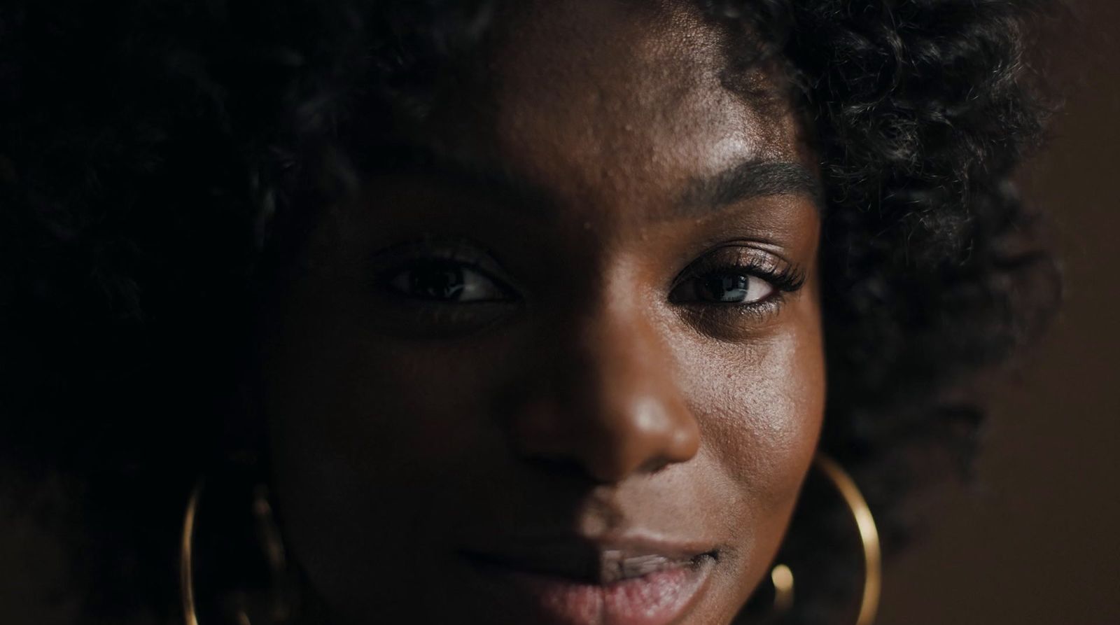 a close up of a person wearing large gold hoop earrings