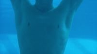 a man is swimming in the water with his hands up