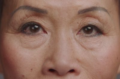 a close up of a woman's face with wrinkles