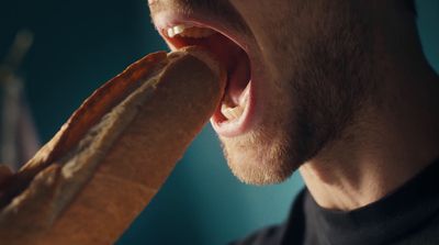 a man holding a hot dog in his mouth