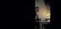 a person sitting at a table in a dark room